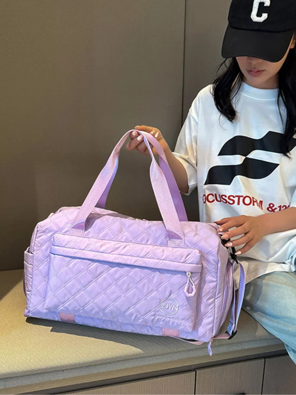 Diamond-quilted travel bag in Taro Purple with versatile straps and front pocket.