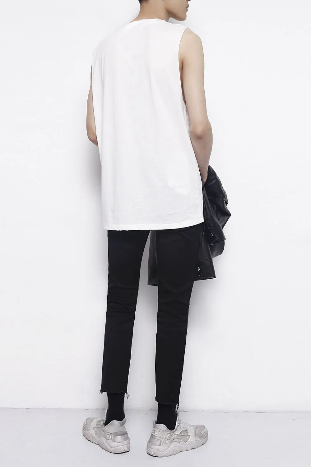 Distressed knee skinny jeans in dark cotton with frayed hem.
