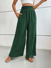 Textured palazzo lounge trousers in dark green with smocked waist and pockets.