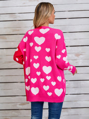 Pink acrylic blend cardigan with white hearts pattern and split red panel sleeve.