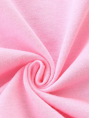 Pink cotton knit fabric detail of baby girls' ruffle top and plaid shorts set.