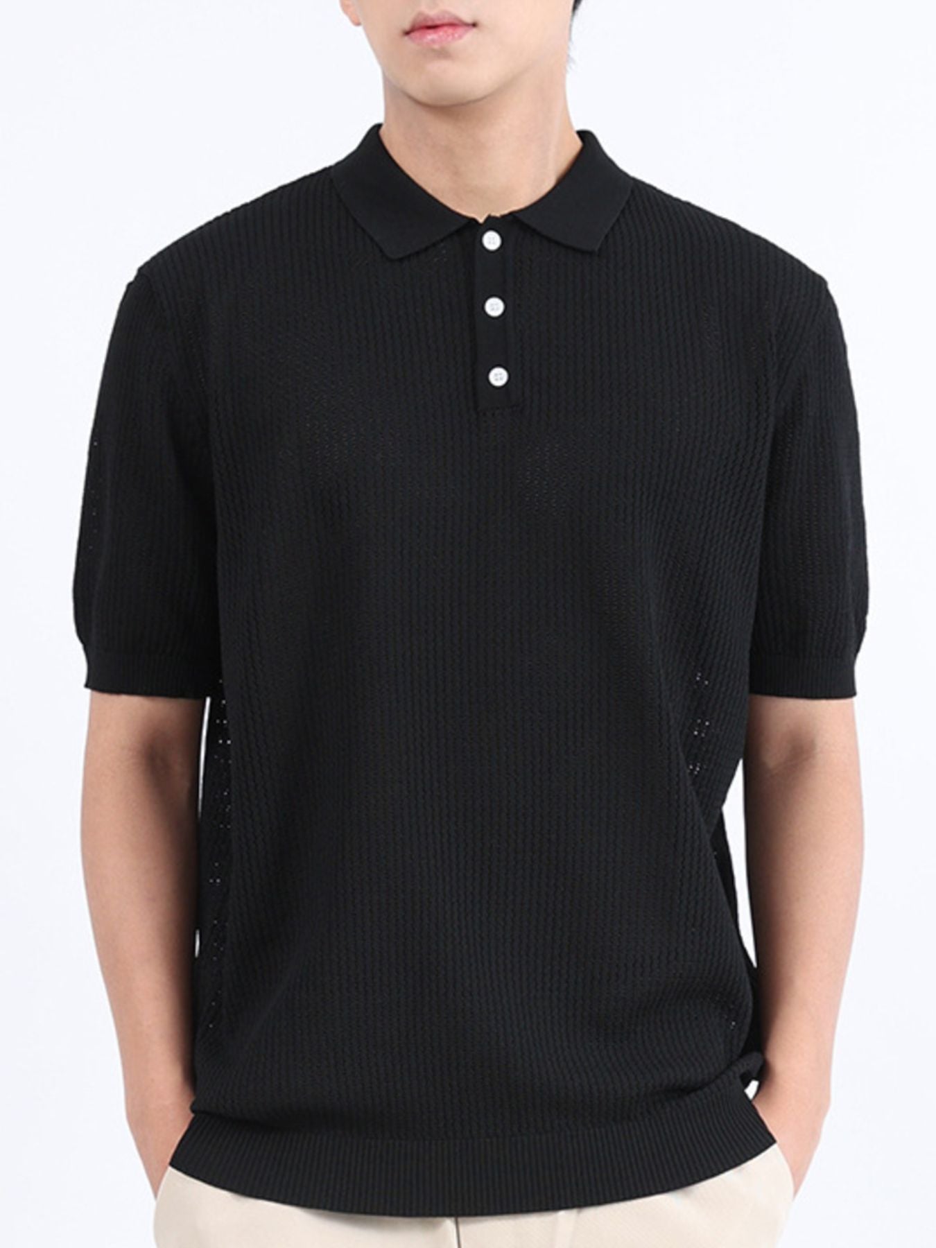Black textured knit polo shirt with classic collar and short sleeves.