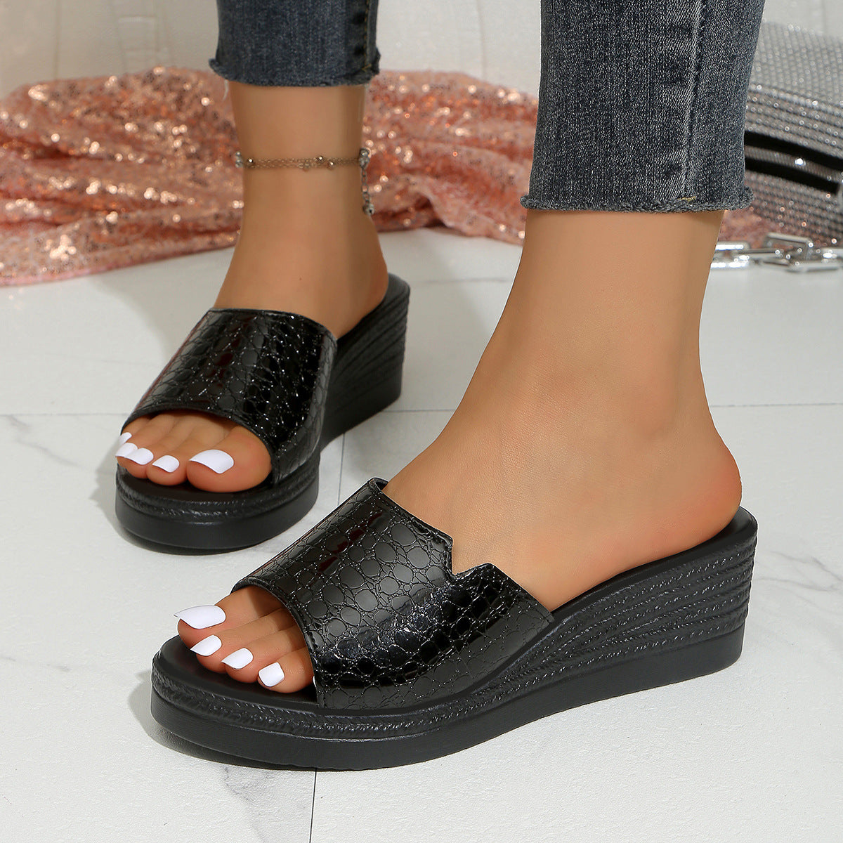 Black crocodile-embossed open-toe wedge sandals with a platform sole.