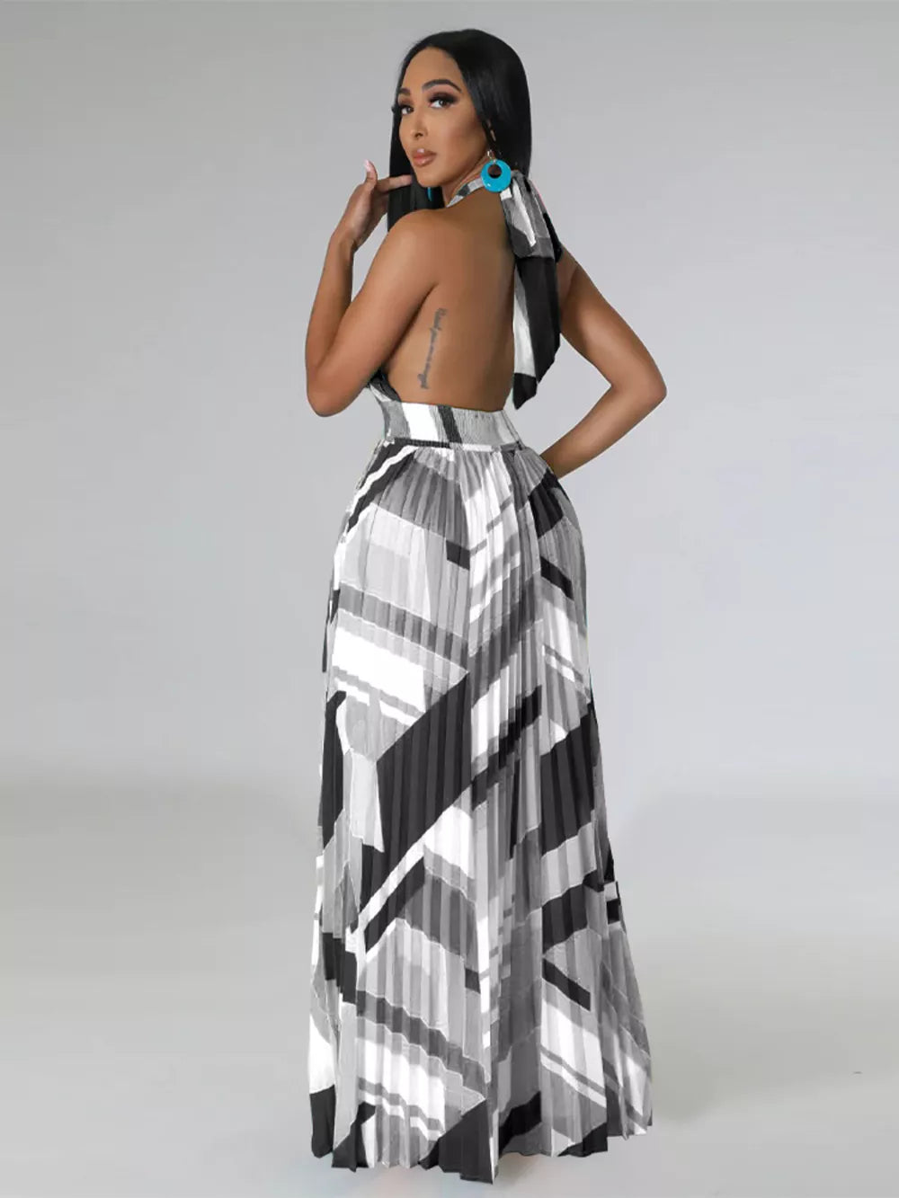 Halter neck maxi dress with geometric print and pleated skirt.