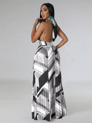 Halter neck maxi dress with geometric print and pleated skirt.