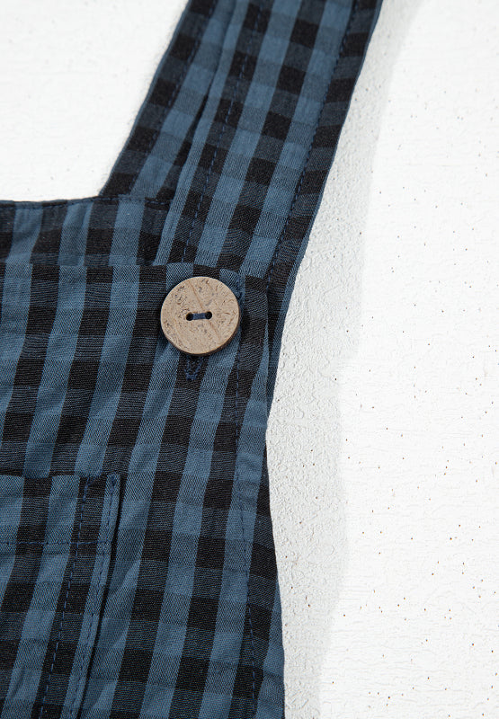 Dark blue gingham overalls with a wooden button detail on the strap.