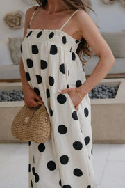Charming cream polka dot maxi dress with pockets and smocked bodice.