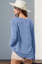 Light blue waffle knit henley shirt with thumbhole cuffs, long sleeves and a relaxed fit.