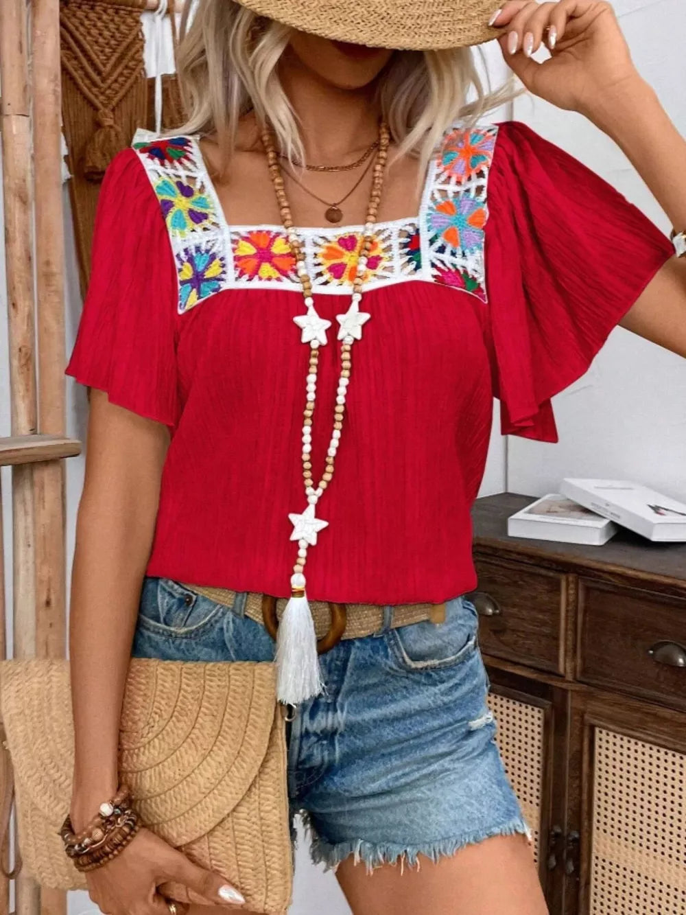 Red embroidered square neck flutter sleeve blouse with colorful floral detail.