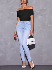 Black off-shoulder ruched t-shirt with short sleeves, styled with light wash jeans.