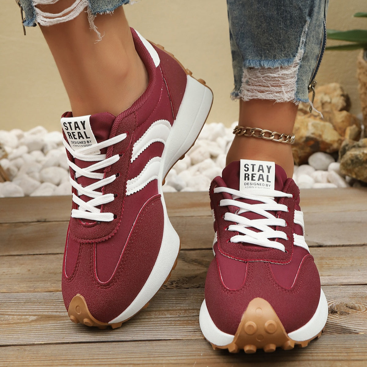Red lace up round toe sneakers with white stripes and chunky sole