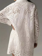 White eyelet longline button-up shirt with intricate cutout details and scalloped hem.