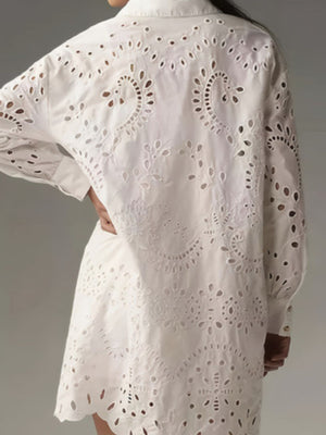 White eyelet longline button-up shirt with intricate cutout details and scalloped hem.