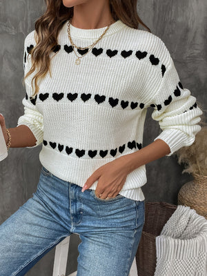 Cream knit sweater with black heart pattern, crew neck, long sleeves, casual style.