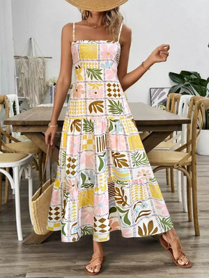 Vibrant cutout back cami dress with a colorful floral and leaf print, tiered skirt, and square neckline.