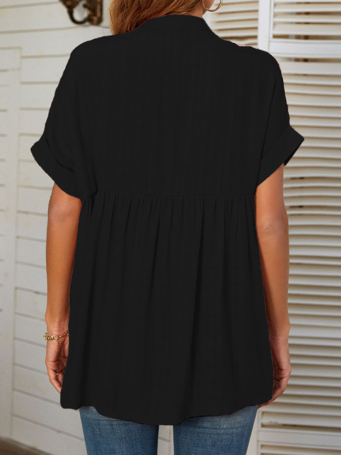 Black linen blend blouse with gathered yoke and cuffed short sleeves.