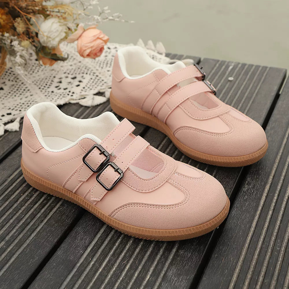 Pink buckle strap Mary Jane inspired sneakers with double buckle detail and suede accents.