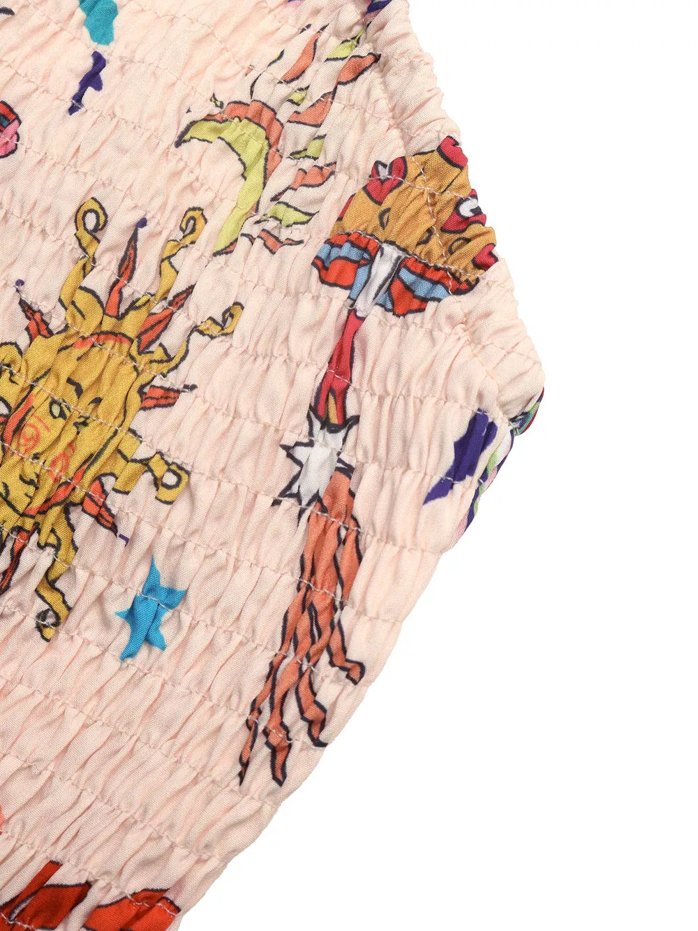 Smocked romper in peach with a whimsical sun, mushroom, and star print.
