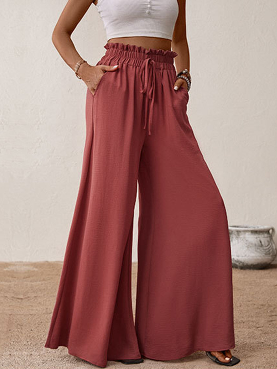 Ruffled waist palazzo trousers in rust with a drawstring and wide legs.