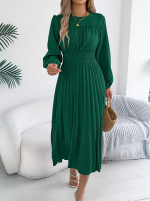 Green midi dress with ruffled smocked waist and pleated skirt.