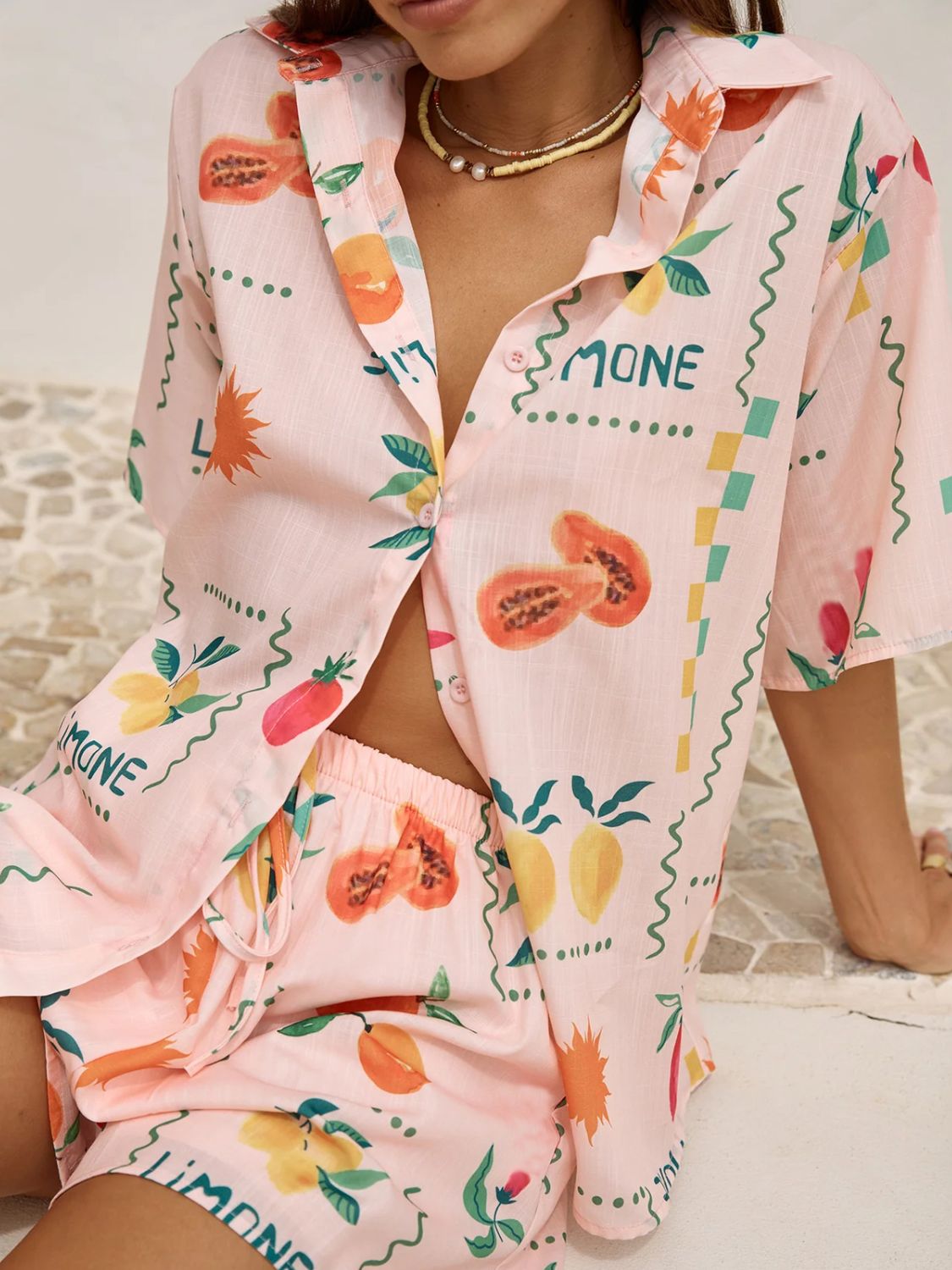 Pink co-ord pajama set with a limoncello print, button-up shirt and shorts.
