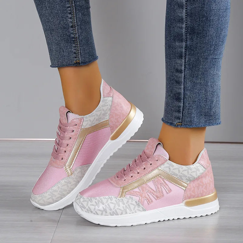Logo monogrammed runner sneakers in blush pink with gold accents and white soles.