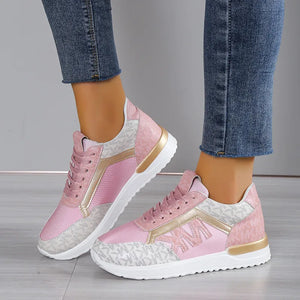 Logo monogrammed runner sneakers in blush pink with gold accents and white soles.