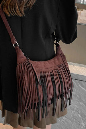 Bohemian suede crescent crossbody bag with fringe detail in dark brown.