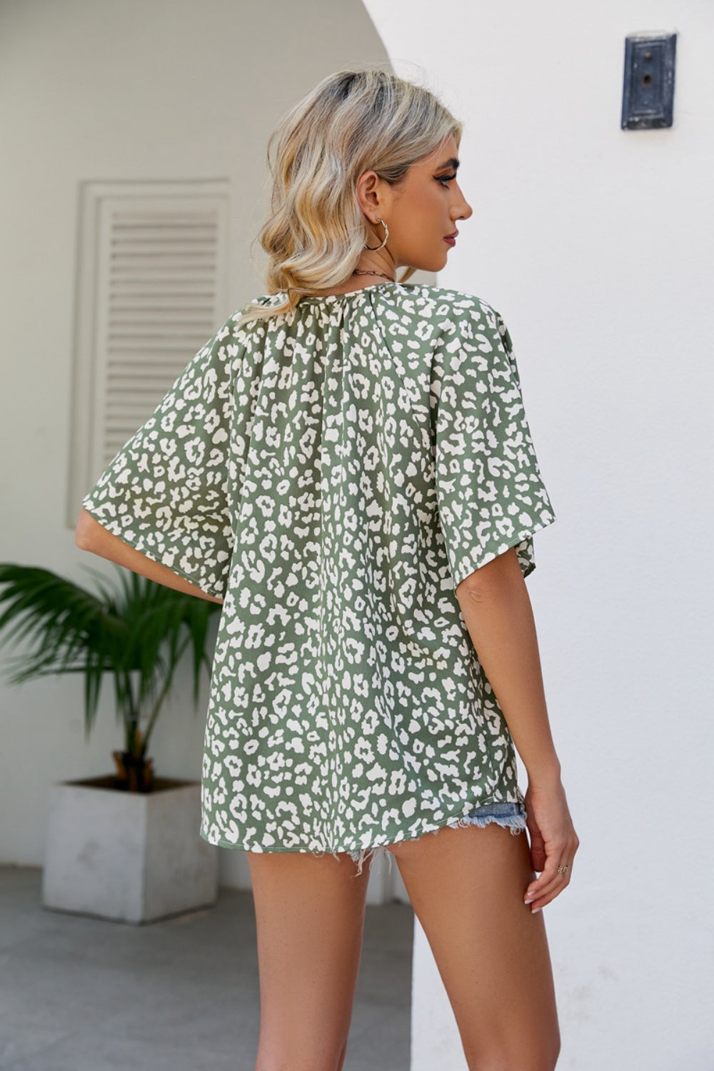 Army green leopard print v-neck blouse with short sleeves and a gathered neckline.