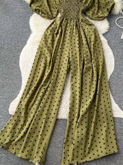 Army green polka dot smocked wide-leg romper with puff sleeves.