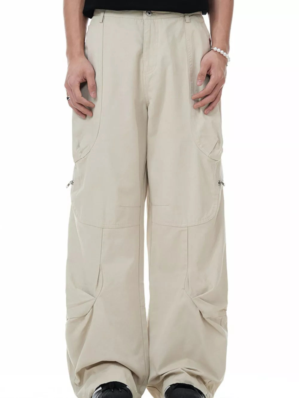 Men's beige cargo pants with multiple pockets and zipper details.