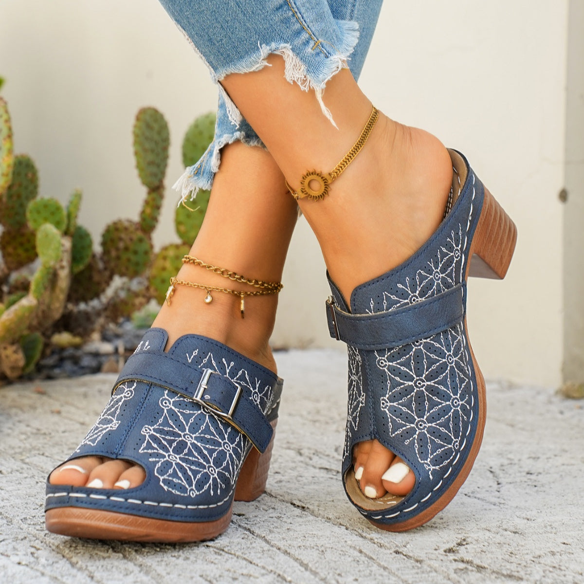 Blue buckle sandals with white floral embroidery and block heel.