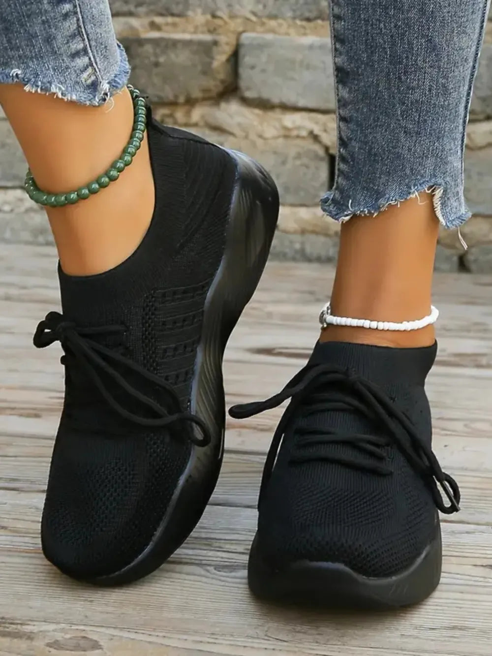 Black knit runner sneakers with sculpted sole and lace-up closure.