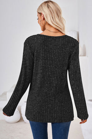 Black ribbed knit sweater with long sleeves and a crew neck.