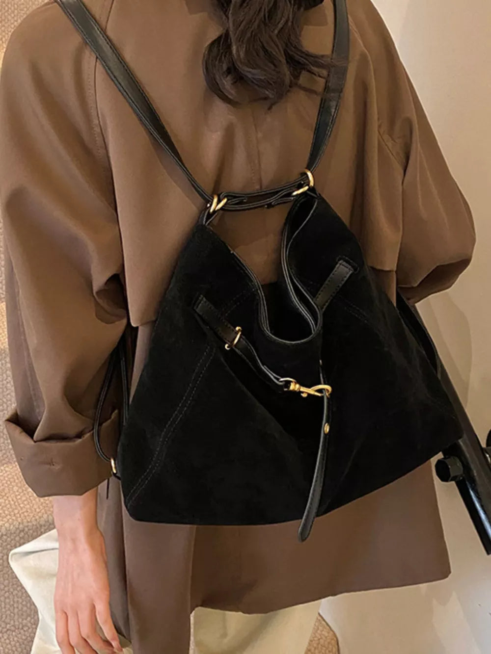 Black suede crossbody bag with gold hardware and adjustable strap
