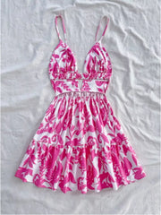 Vibrant floral cutout mini dress with spaghetti straps and tiered hem.