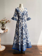 Maxi dress with blue floral print, V-neck, drawstring waist, and lace-trimmed bell sleeves.