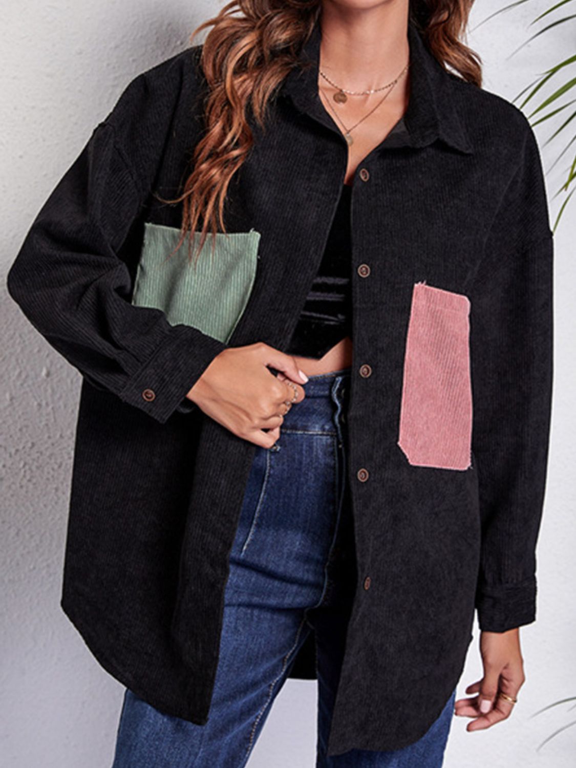 Black corduroy overshirt with contrast pink and green patch pockets.