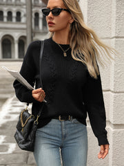 Black cable knit sweater with crew neck and long sleeves.