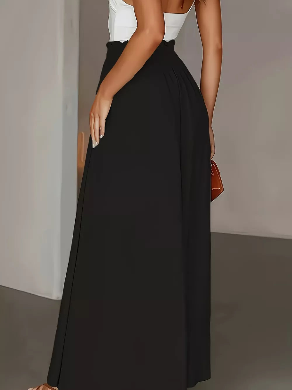 Black wide-leg trousers with paperbag waist detail, full length.