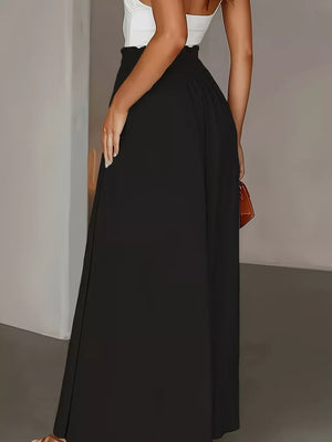 Black wide-leg trousers with paperbag waist detail, full length.