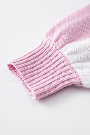 Dusty pink and white acrylic knit sweater sleeve detail with ribbed cuff.