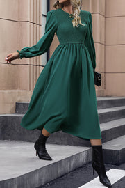 Dark green polyester midi dress with smocked bodice and long puff sleeves.