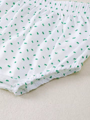 White baby shorts with green dobby dots and elastic waistband and leg openings.