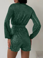 Dark green sequin wrap romper with blouson sleeves and cinched waist.