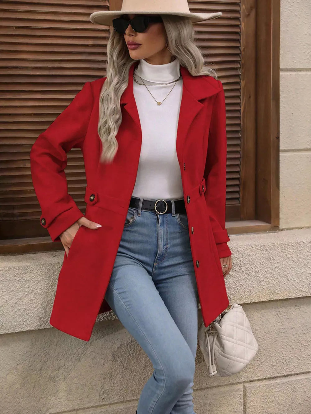 Scarlet button-up trench coat with cinched waist and button details, worn open over a white turtleneck.