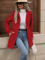 Scarlet button-up trench coat with cinched waist and button details, worn open over a white turtleneck.