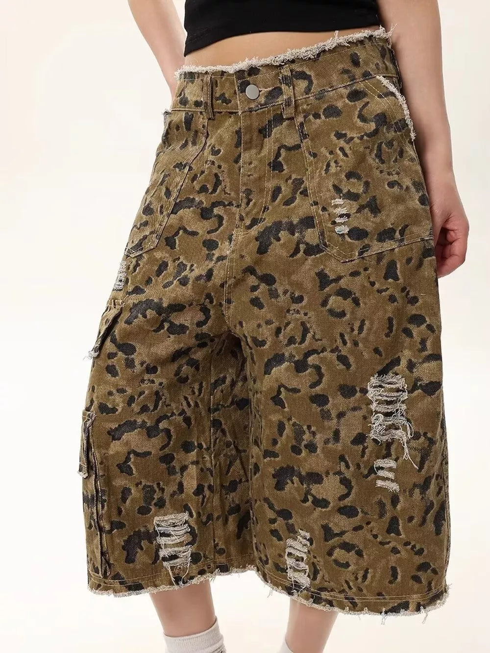 Distressed camo print denim shorts for men with frayed hem and cargo pockets.