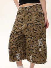 Distressed camo print denim shorts for men with frayed hem and cargo pockets.