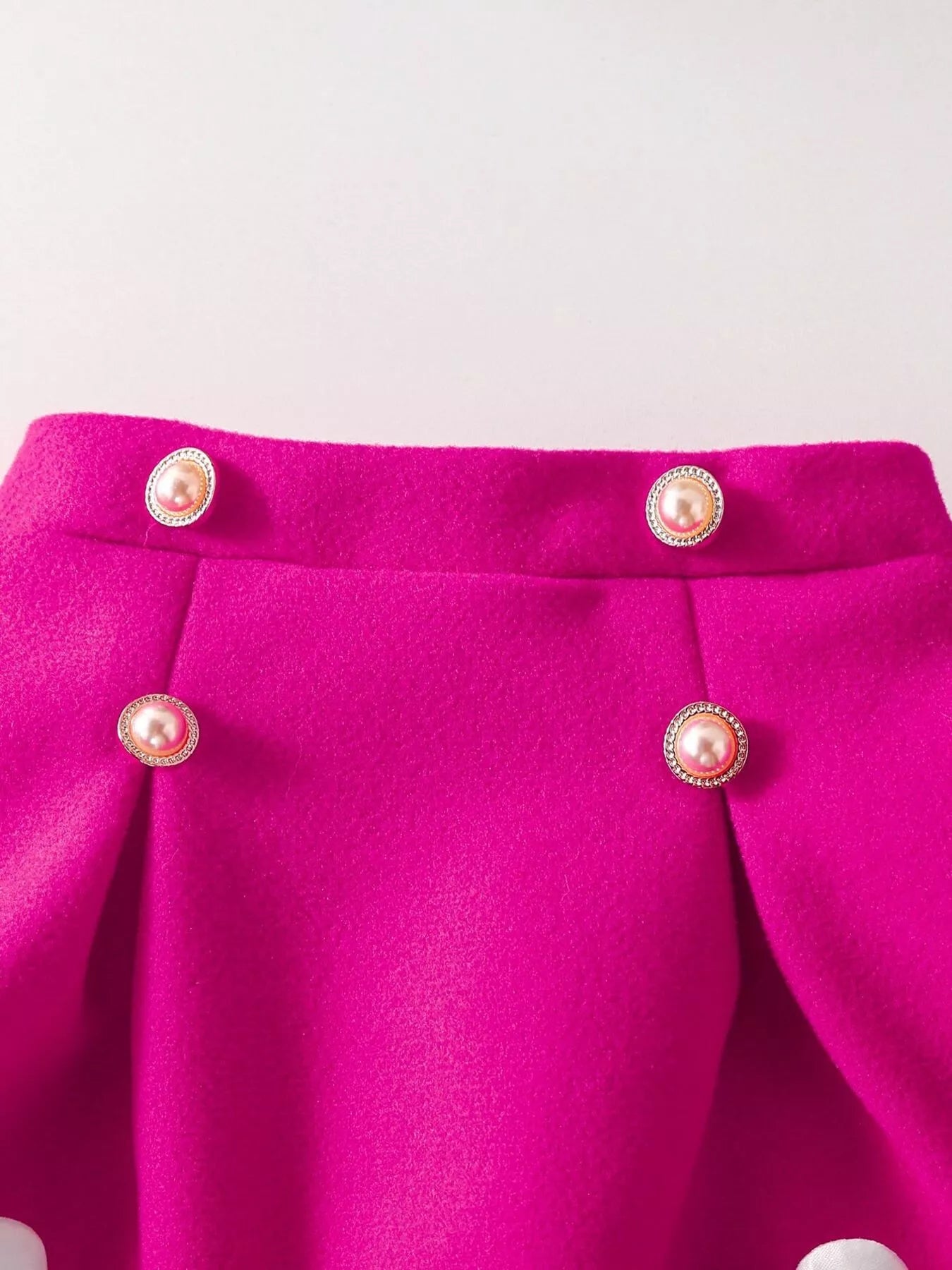 Hot pink knit skirt with pearl buttons and pleats